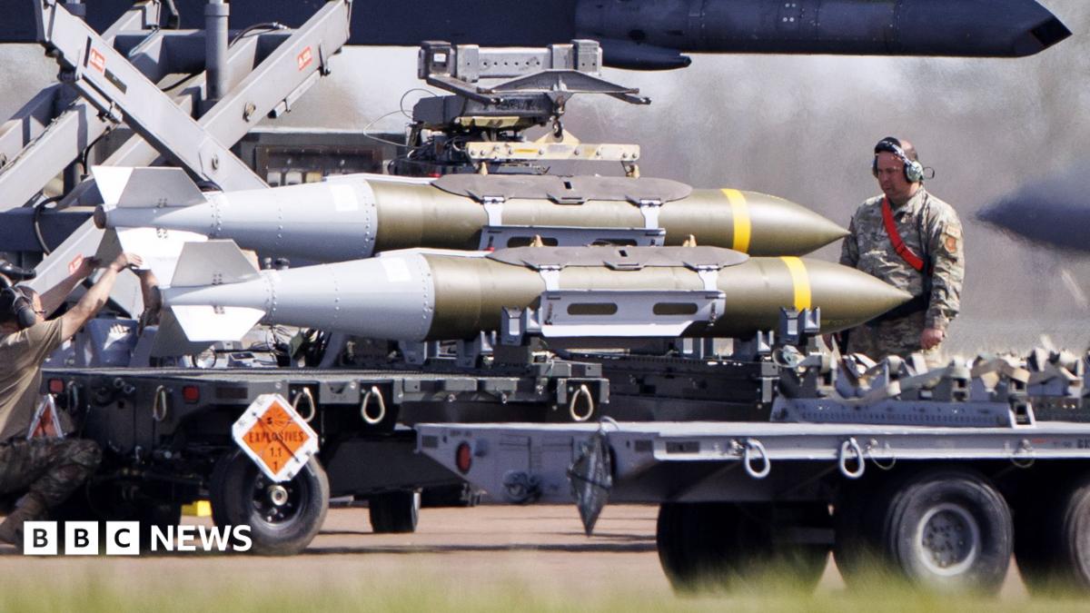 A member of the US military watches on as weapons are loaded onto an American aircraft at RAF Fairford