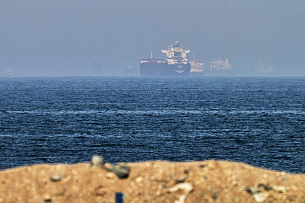 Cargo ships are seen at sea near the Strait of Hormuz, as viewed from a rocky shoreline near Khor Fakkan, United Arab