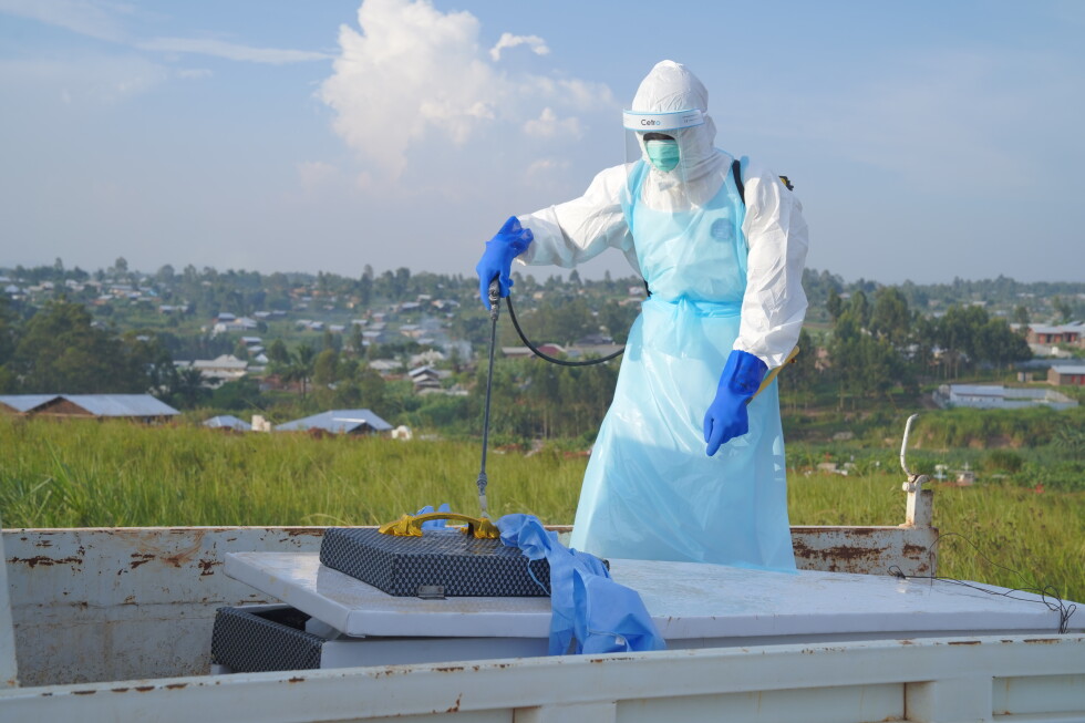 A health worker sprays the coffin containing the remains of Jacques Lobo Dhena, who died of Ebola, during a burial service
