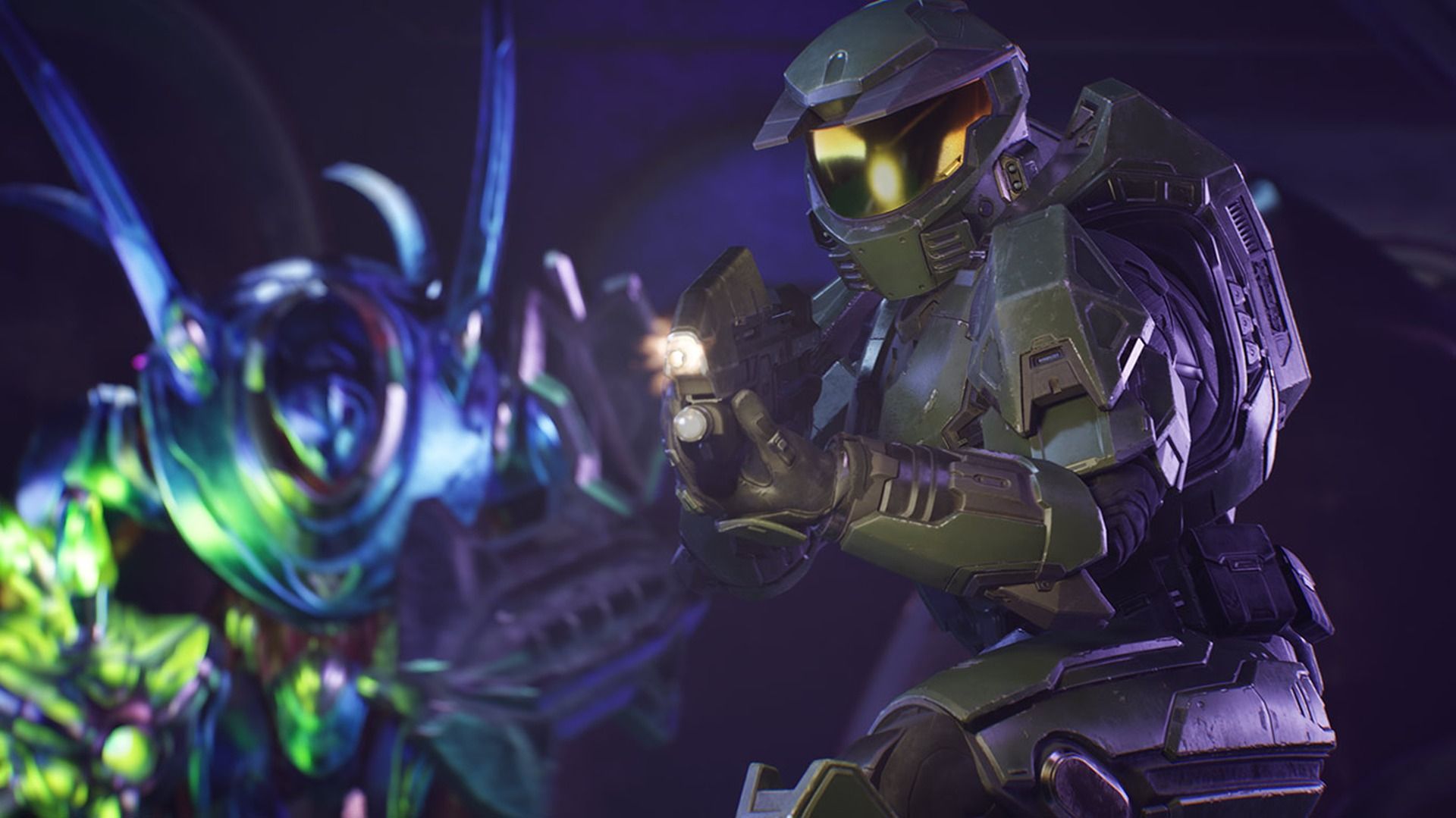 Master Chief in green armor holds a pistol with a flashlight in a dark environment, facing a glowing blue and green alien